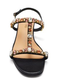 Sandal de cuero negro con diseño de tira en T adornada con diversos strass coloridos, incluyendo acentos en rosa, dorado y transparente, con suela plana.