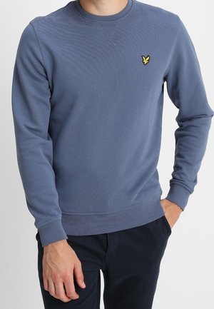 Sweat-shirt bleu en mélange de coton, doté d'un col rond, de poignets côtelés et d'un petit logo jaune sur la poitrine.