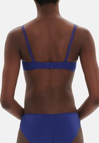 Lila Lingerie-Set bestehend aus einem Bralette mit verstellbaren Trägern und einem Hakenverschluss auf der Rückseite, begleitet von einem passenden Slip.