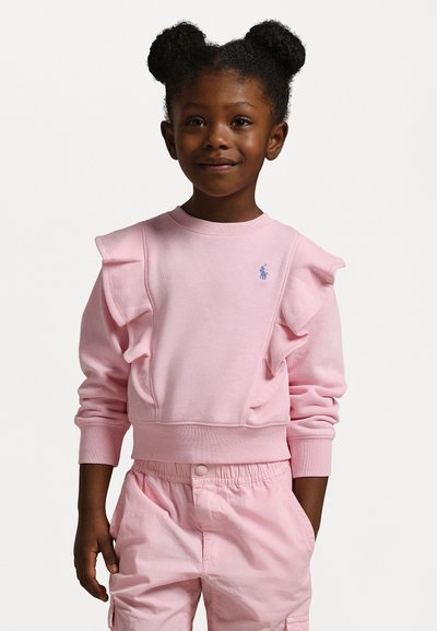 Rosa sweatshirt med volangdetaljer, stickad textur, rundad halsringning och liten blå logotyp, i kombination med matchande rosa byxor.