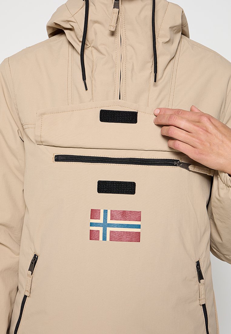 Beige windbreaker met een half-rits ontwerp, voorzien van een voorzak met rits en een Noorse vlag patch. Verstelbare capuchon met zwarte trekkoorden.