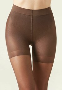 Brune gennemsigtige tights med forstærket talje og glat tekstur, der har en subtil mønstret detaljering på lårene. Synlig elastisk bånd.
