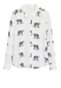 Chemise blanche à manches longues présentant un imprimé léopard noir sur toute sa surface. Fabriquée en tissu léger avec un col classique et une fermeture à boutons.