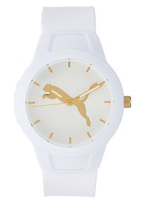 Montre blanche avec des marqueurs d'heure dorés, des aiguilles dorées et un logo Puma doré au centre, dotée d'un bracelet en silicone blanc.