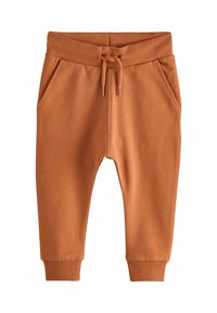 Oranssit sweatsarit, joissa on nyörivö, ribatatut hihansuut ja kaksi sivutaskua, valmistettu pehmeästä, teksturoidusta kankaasta.