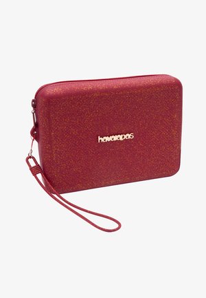 Red textured clutch bag with a zip closure, gold logo, and detachable wrist strap. Sparkling finish with a rectangular design.
