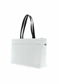 Sac fourre-tout blanc avec des poignées en cuir noir, présentant un design géométrique élégant et deux poches avant avec fermeture éclair.