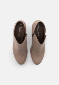 Botas de tobillo beige de ante con una textura suave, que cuentan con un cierre lateral y un diseño de punta afilada. Talla 37.