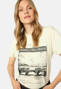 Crème katoenen T-shirt met een zwarte grafische afdruk van de Ponte Vecchio brug in Florence, met korte mouwen en een relaxed fit.