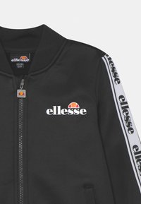 Giacca bomber nera realizzata in tessuto liscio, dotata di zip frontale, logo bianco e strisce laterali a contrasto con il nome del marchio.