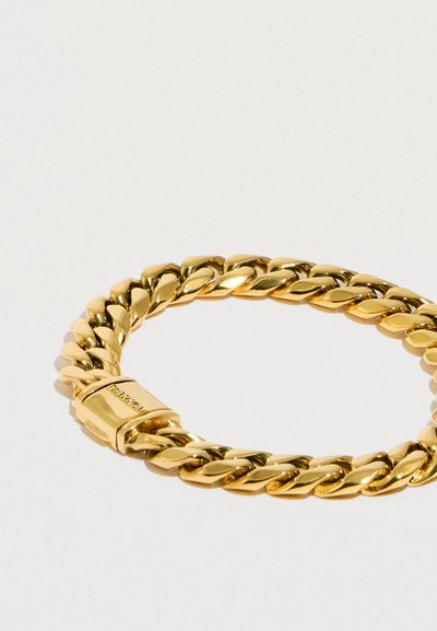 Zlatý náramek s propojenými zakřivenými články s lesklým povrchem. Obsahuje zapínání s vyraženým logem značky.