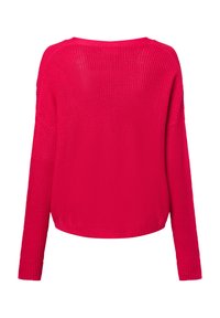 Lange mouwen, losvallende trui van felroze brei. Heeft een geribbelde textuur en een brede halslijn, de zoom eindigt ter hoogte van de taille.