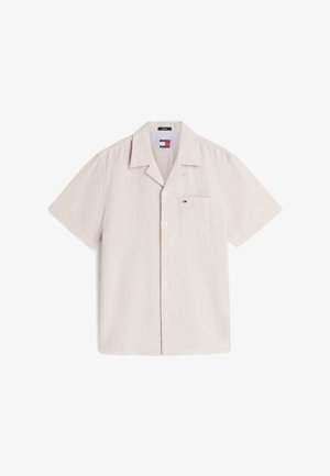 Beige värinen, lyhythihainen nappipaita, jossa on lehtikaulus ja pieni logo vasemmassa rintataskussa, asetettuna tasaiselle valkoiselle taustalle.