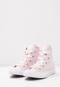 Rosa högskor av canvas med satin snörning och silverögon. Vit gummitåhätta och sula med en subtil rosa rand. Mjuk texturerad foder.