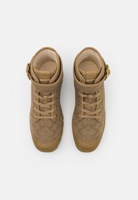 Baskets beiges en toile, avec un motif texturé, bout arrondi, semelles en caoutchouc et accents en métal. Design à lacets.