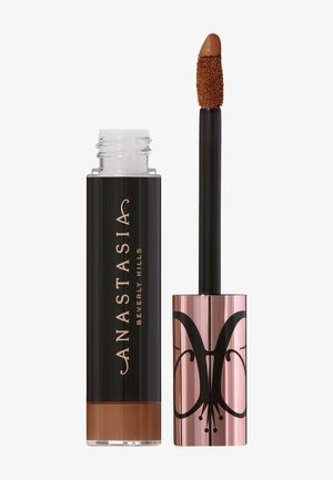 Rouge à lèvres liquide dans un tube transparent et noir ; l'applicateur possède une pointe douce de couleur marron. Des accents dorés et rose doré rehaussent le design.
