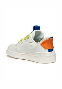 Baskets en cuir blanc avec lacets verts, boucle de talon bleue et accent orange au niveau du talon. Elles possèdent une semelle texturée et un col rembourré pour le confort.