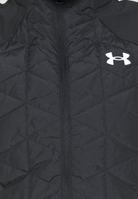 Chaqueta negra acolchada con cremallera frontal completa, presenta un patrón geométrico de diamantes y un logotipo blanco en la parte superior derecha.