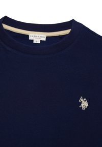 Granatowy bawełniany sweter z okrągłym dekoltem, z prążkowanym kołnierzykiem i małym haftowanym logo w białym kolorze na piersi. Rozmiar: L.