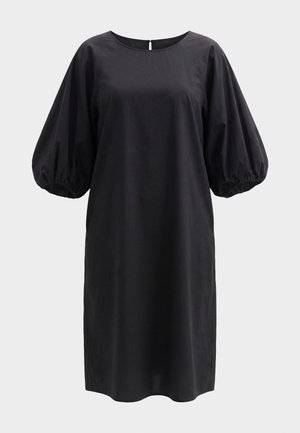 Rochie neagră până la genunchi, cu guler rotund, croială lejeră și mâneci voluminoase trei-sferturi bufante, cu manșete elastice strânse.