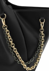 Borsa tote in pelle nera con manici a catena bicolore—oro e metallo grigio scuro—che aggiungono texture con una finitura liscia e una forma strutturata.