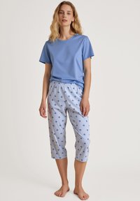 Lichtblauw T-shirt met korte mouwen en een ronde hals, gecombineerd met cropped gestreepte broek met kleine blauwe palmbomenprints en een elastische tailleband.