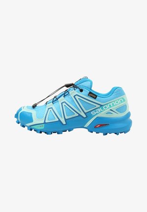 Chaussure de trail Salomon bleue et turquoise clair avec une semelle robuste, un système de laçage rapide et une étiquette Gore-Tex sur le côté.