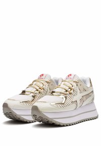 Sneakers hebben een wit en gouden ontwerp met mesh en textuurmateriaal, een stevige zool en gestreepte accenten aan de zijkanten en op de neus.