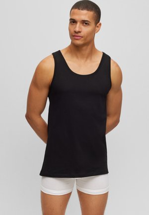 Zwarte mouwloze tanktop van katoen, met een ronde halslijn en een gladde afwerking. Draagt met witte boxershorts.