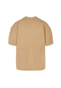 Bežové oversized tričko vyrobené z jemnej bavlny, so zaobleným výstrihom a krátkymi rukávmi, s hladkou a jednofarebnou textúrou.