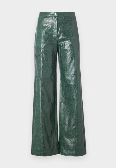 Groene, wijde broek van glanzend materiaal. Heeft een zijzak en een knoopsluiting, met een gestructureerde afwerking en een gladde uitstraling.