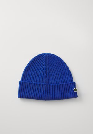 Beanie a coste blu con risvolto e un piccolo logo ricamato verde sul lato. Texture morbida e design aderente.