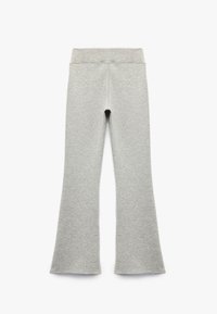 Lys grå flare leggings lavet af blødt, strækmateriale med en bred talje og glat tekstur, uden synlige mønstre eller hardware.