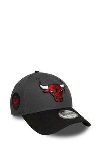 Gorra de béisbol gris con visera negra, que presenta un logo bordado rojo de los Chicago Bulls en la parte frontal y un parche circular de logo en el lado.
