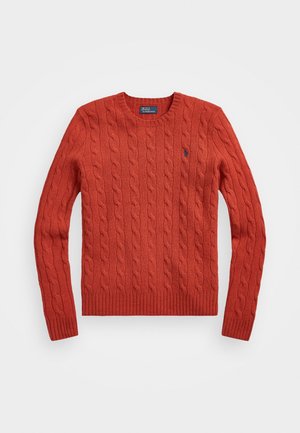 Pull à col rond en maille torsadée orange rouille à manches longues avec poignets et bas en côtes, comportant un petit logo brodé sur la poitrine gauche.