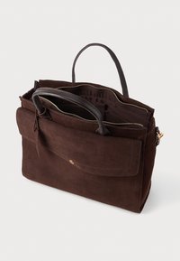 Barna velúr kézi táska bőr fogantyúkkal, felső cipzárral és elülső hajtókás zsebbel. A belső rész sima béléssel rendelkezik, amely praktikus a mindennapi használatra.