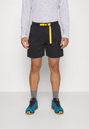 Czarne szorty z żółtym paskiem, wykonane z lekkiego materiału. W zestawie niebiesko-czarne buty sportowe i szare skarpetki. Długi rękaw top z wzorem.