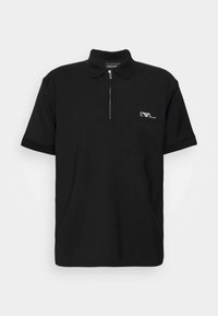 Černé polo tričko vyrobené z texturované tkaniny, s rychlopáskovým límcem, krátkým rukávem a přední kapsou s logem.