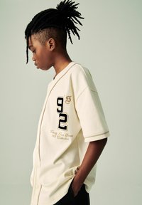 Next VARSITY SET  - REGULAR FIT - Printtipaita - cream black