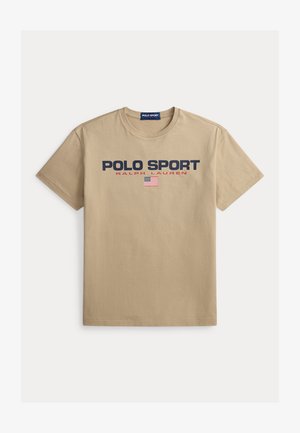 Tricou bej din bumbac, cu mâneci scurte, având inscripțiile „POLO SPORT” și „RALPH LAUREN” în text albastru închis și roșu, și un mic accent cu steagul american.