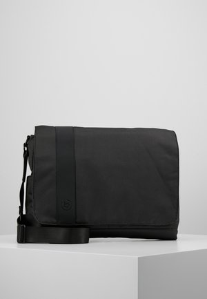 Sac messager noir en tissu texturé, doté d'une large bandoulière réglable et d'une fermeture à rabat avec un accent logo sur le devant.