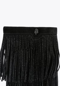 Czarna zamszowa torba z długimi frędzlami, błyszczącymi detalami i dekoracyjnym zapięciem na guzik u góry.