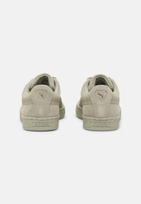 Khaki zamszowe trampki z teksturowanymi gumowymi podeszwami, zaokrąglonym tyłem oraz logo Puma na pięcie. Miękka podszycie z tkaniny.