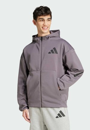 Grå hoodie i mjukt material, med dragkedja framtill, två fickor och svarta logotryck på bröstet och ärmen.