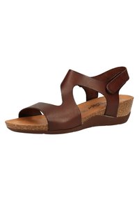 Sandal in pelle marrone con punta aperta, cinturini larghi e chiusura in velcro. Presenta un tacco a zeppa in sughero e una fodera interna liscia.