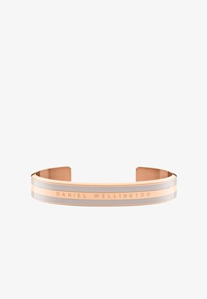 Rózsaarany karkötő, két vízszintes csíkkal ezüst és krém színben, amelyen a "DANIEL WELLINGTON" felirat található a külső felületen.