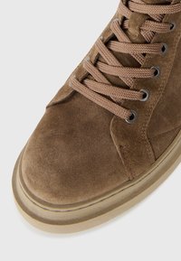Braune Wildleder-Hochtop-Sneaker mit strukturierter Oberfläche, runder Zehenpartie und beiger Gummisohle. Ausgestattet mit braunen Schnürsenkeln und Metallösen für einen sicheren Sitz.