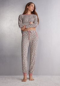 Floral-patroon pyjama set van zachte stof, met een lang mouwtop met roze rand en bijpassende broek met een elastische tailleband en boorden.