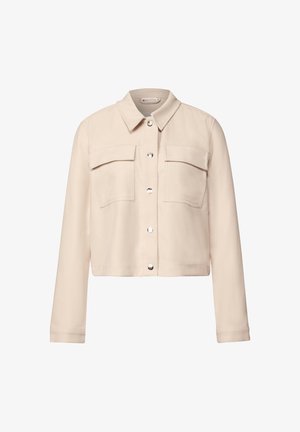 Beige cropped jacket with a collared neckline, two chest pockets, and shiny silver snap buttons. Smooth fabric with a subtle texture.