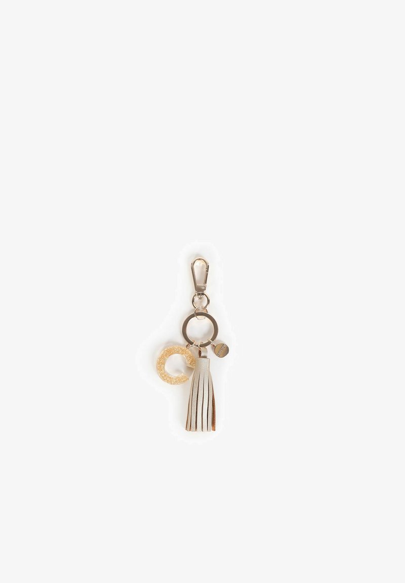 Sleutelhangeraccessoire met een metalen sluiting, een ronde gouden glitterhanger en een crèmekleurige tassel met bruine accenten.